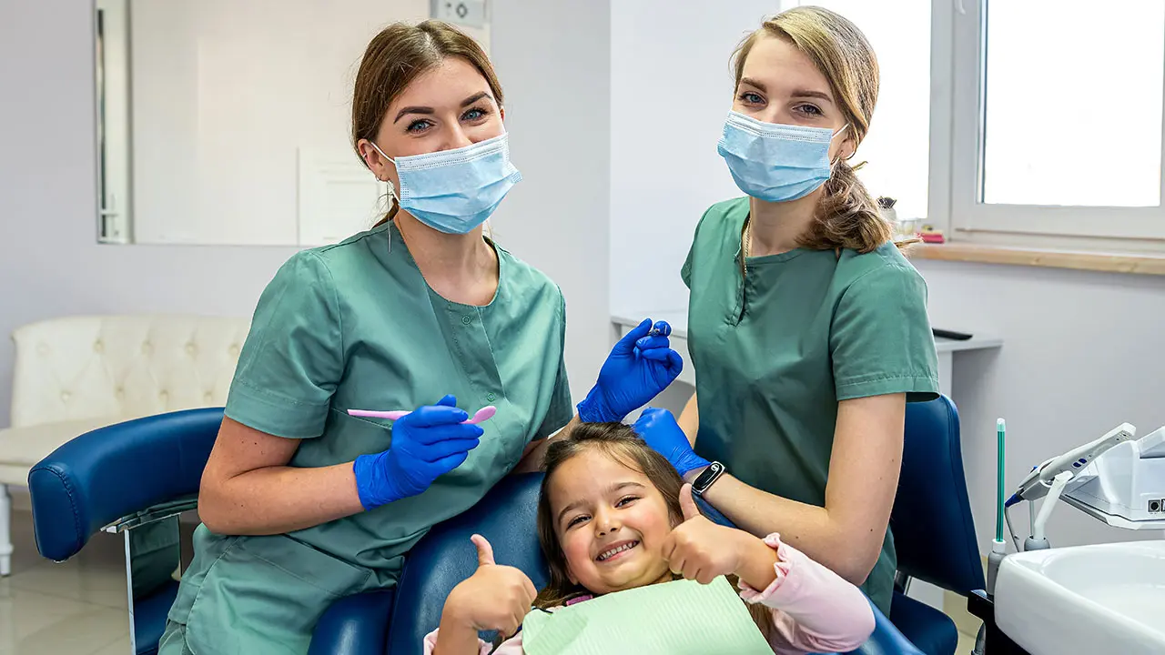 Pediatric dental assistants in Georgia working with a child patient — salary for dental assistant in Georgia, 2025 pay insights.